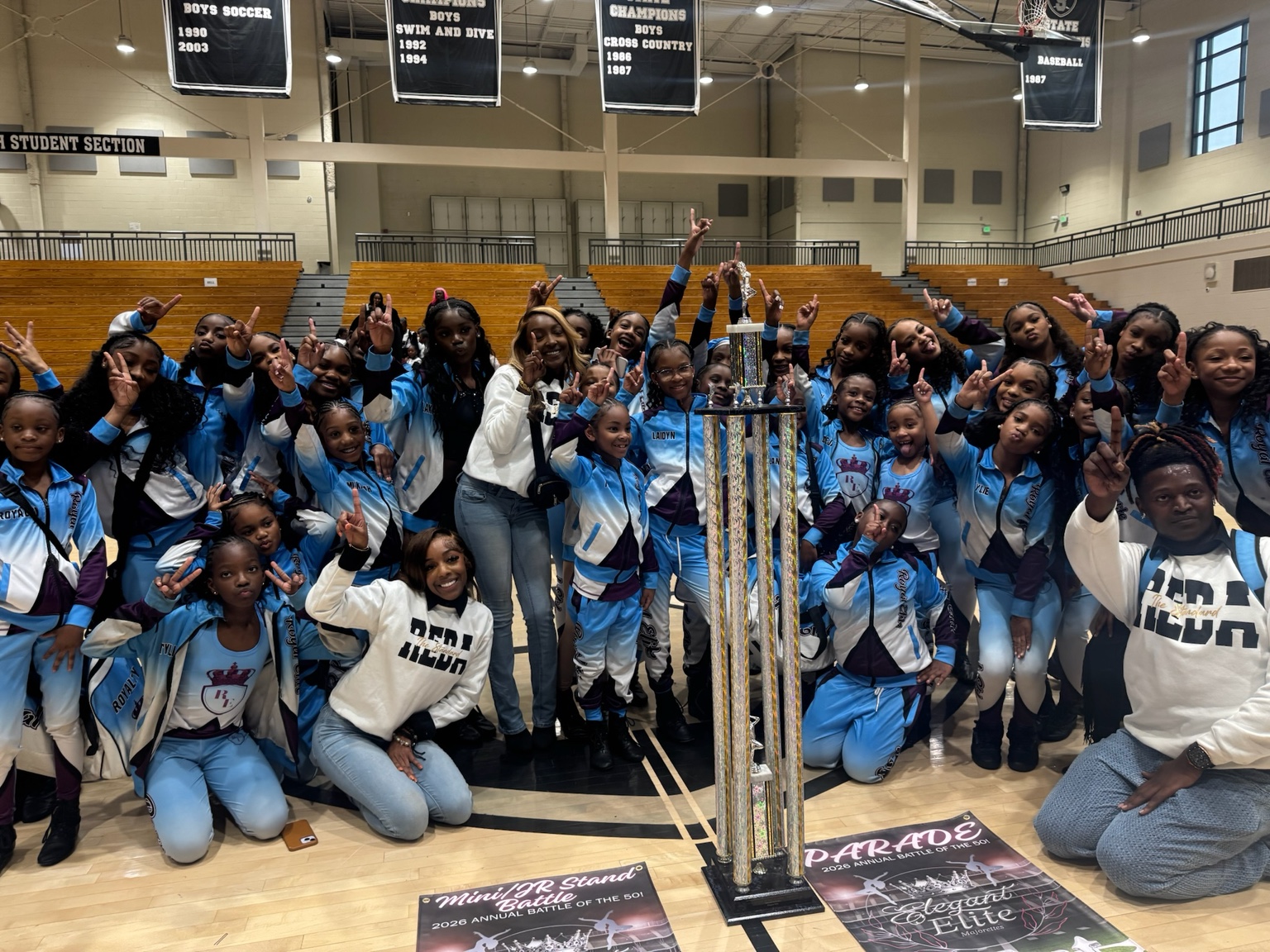 Royal Elite dancers celebrating a championship with a trophy